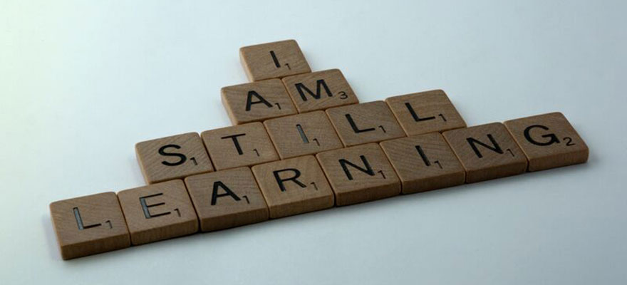 Scrabble tiles spelling 'Still Learning'