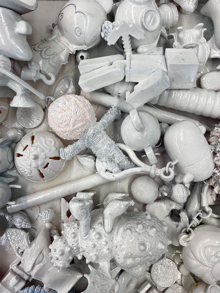 A series of small objects that have been covered in white paint are clustered together